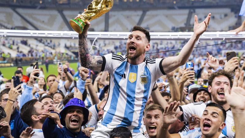 Lionel Messi celebrates with the World Cup trophy
