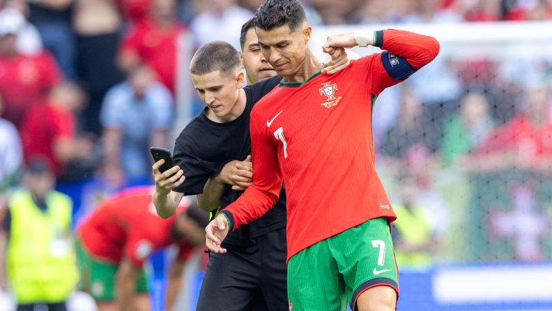 A pitch invader takes a selfie photograph with Cristiano Ronaldo during the UEFA Euro 2024 match between Turkiye v Portugal