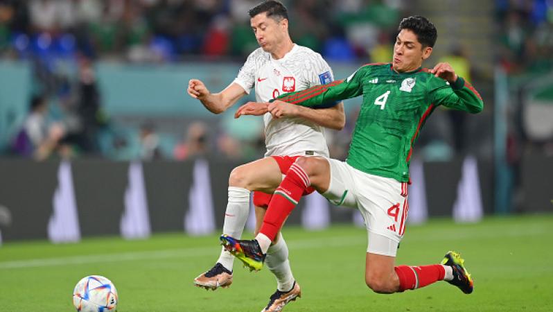 Robert Lewandowski (izquierda) y Edson Álvarez (derecha) disputan un balón.