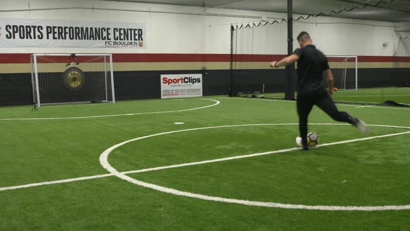 Leigh kicks at ball at a gong.