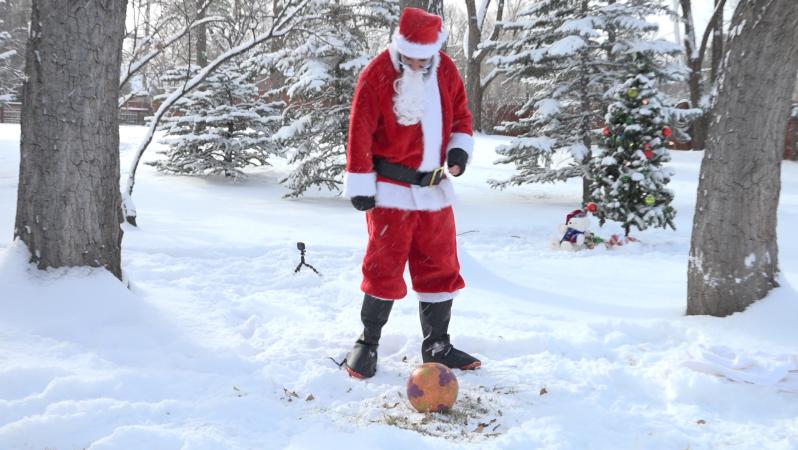 Santa fails at an attempt to kick over a Christmas tree.