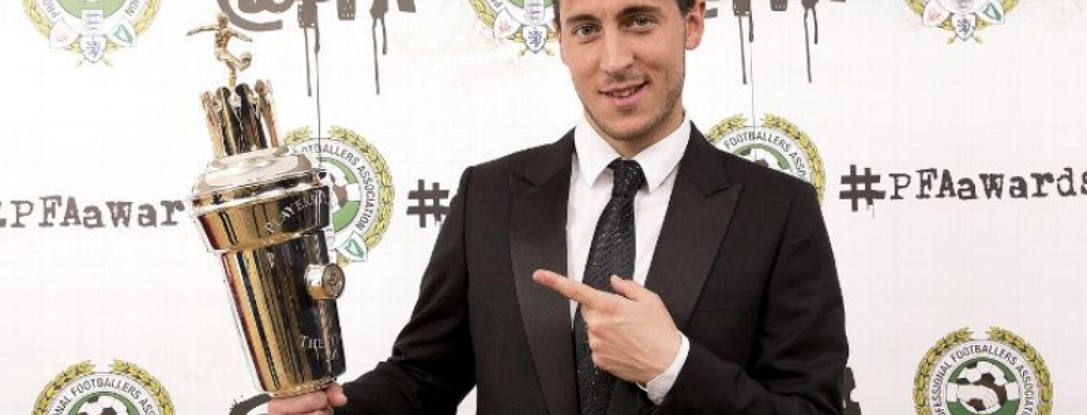 Eden hazard holding and pointing to the PFA Player of the Year award. 