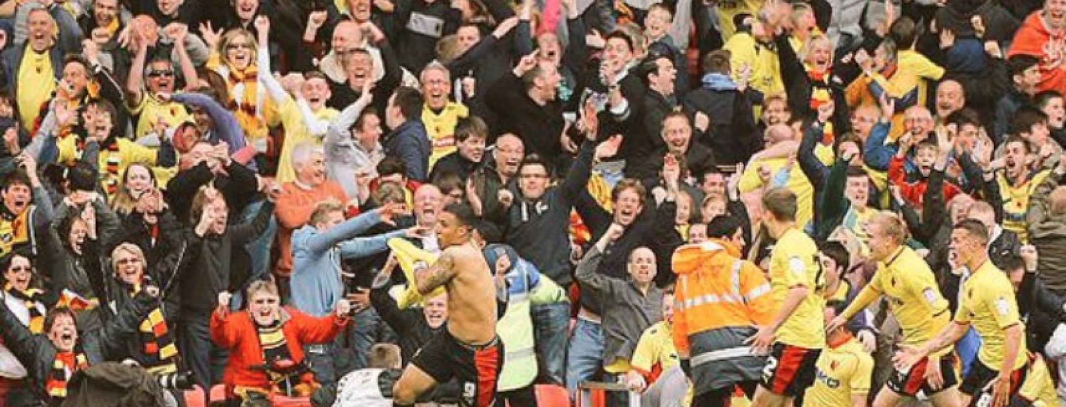 Deeney celebrates with a raucous crowd in the background. 