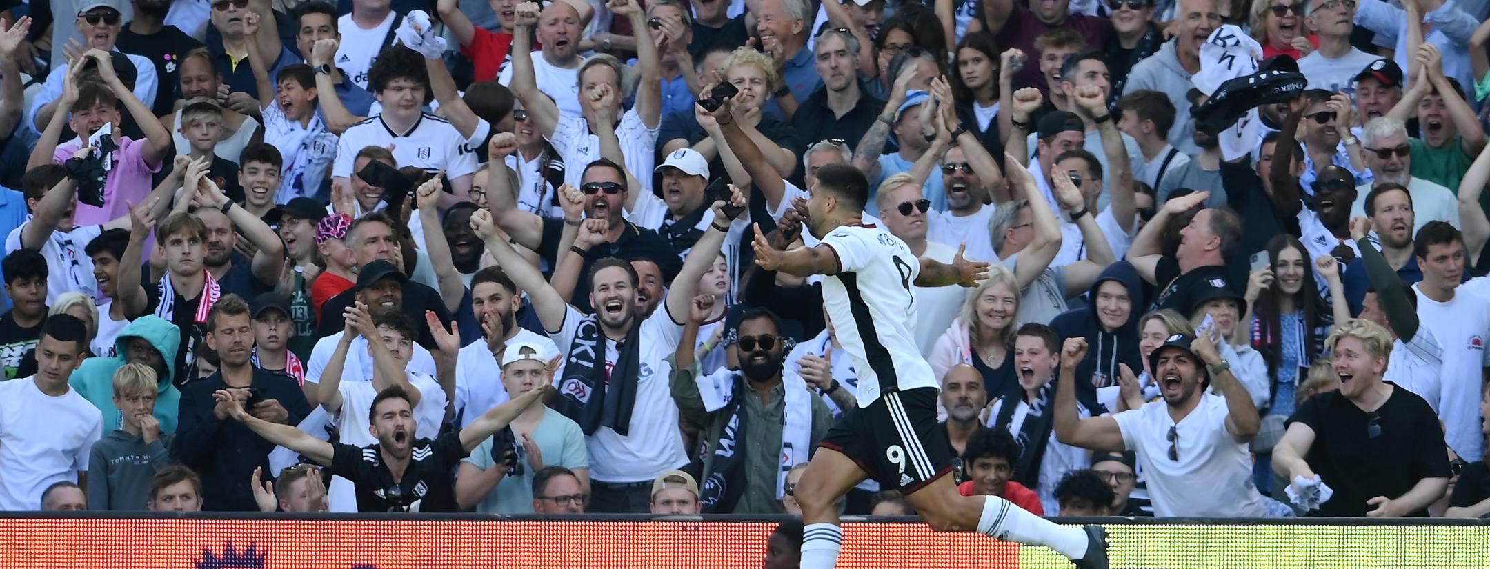 Aleksandar Mitrović celebrates with Fulham fans after scoring his side's first goal against Liverpool