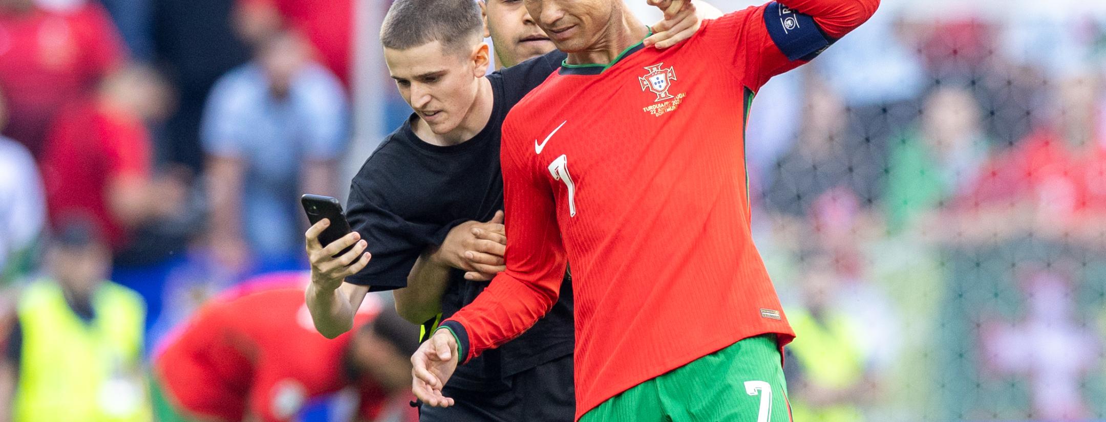A pitch invader takes a selfie photograph with Cristiano Ronaldo during the UEFA Euro 2024 match between Turkiye v Portugal