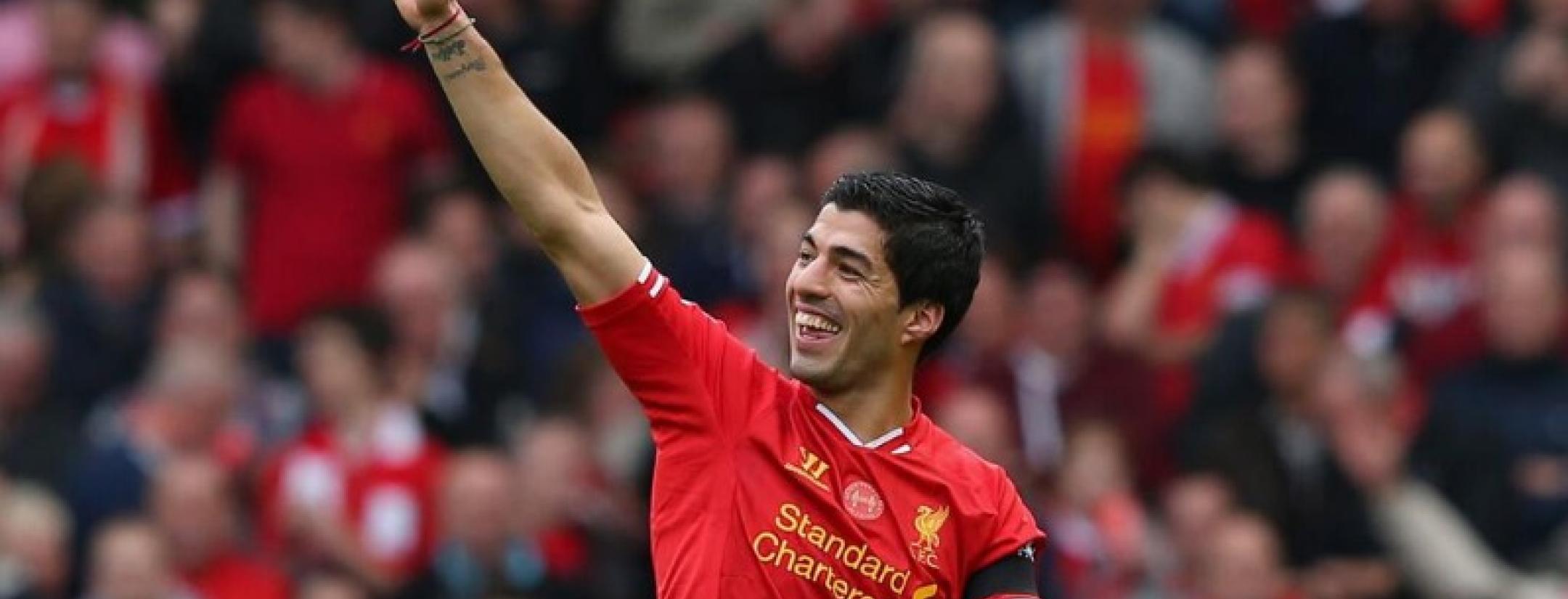 Luis Suarez waving to fans on the pitch after a recent Liverpool match
