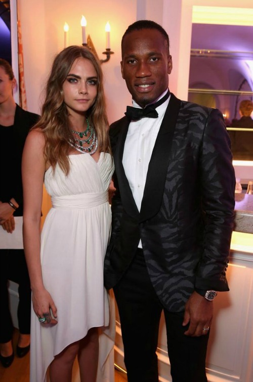 Drogba is pictured standing next to Cara Delevingne, presumably at some party. Drogba still looks like a boss. Cara looks stunning in a white dress of flowing folds. 